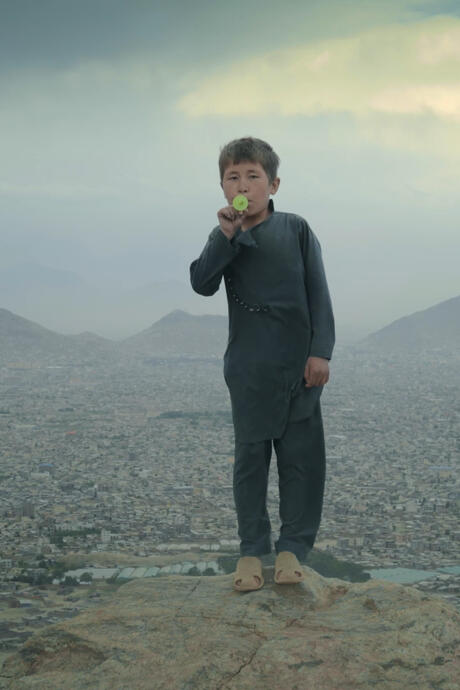 Un jeune garçon jouant du kazoo sur le haut plateau près de Kaboul