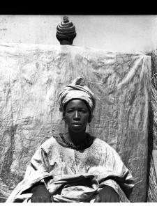 portrait de femme en boubou, devant une personne de dos tenant un pagne tendu portrait de femme en boubou, devant une personne de dos tenant un pagne tendu