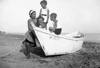 Toni Grand, debout avec ses deux frères et leur mère à Sainte Marie de la Mer
