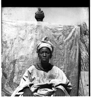portrait de femme en boubou, devant une personne de dos tenant un pagne tendu portrait de femme en boubou, devant une personne de dos tenant un pagne tendu