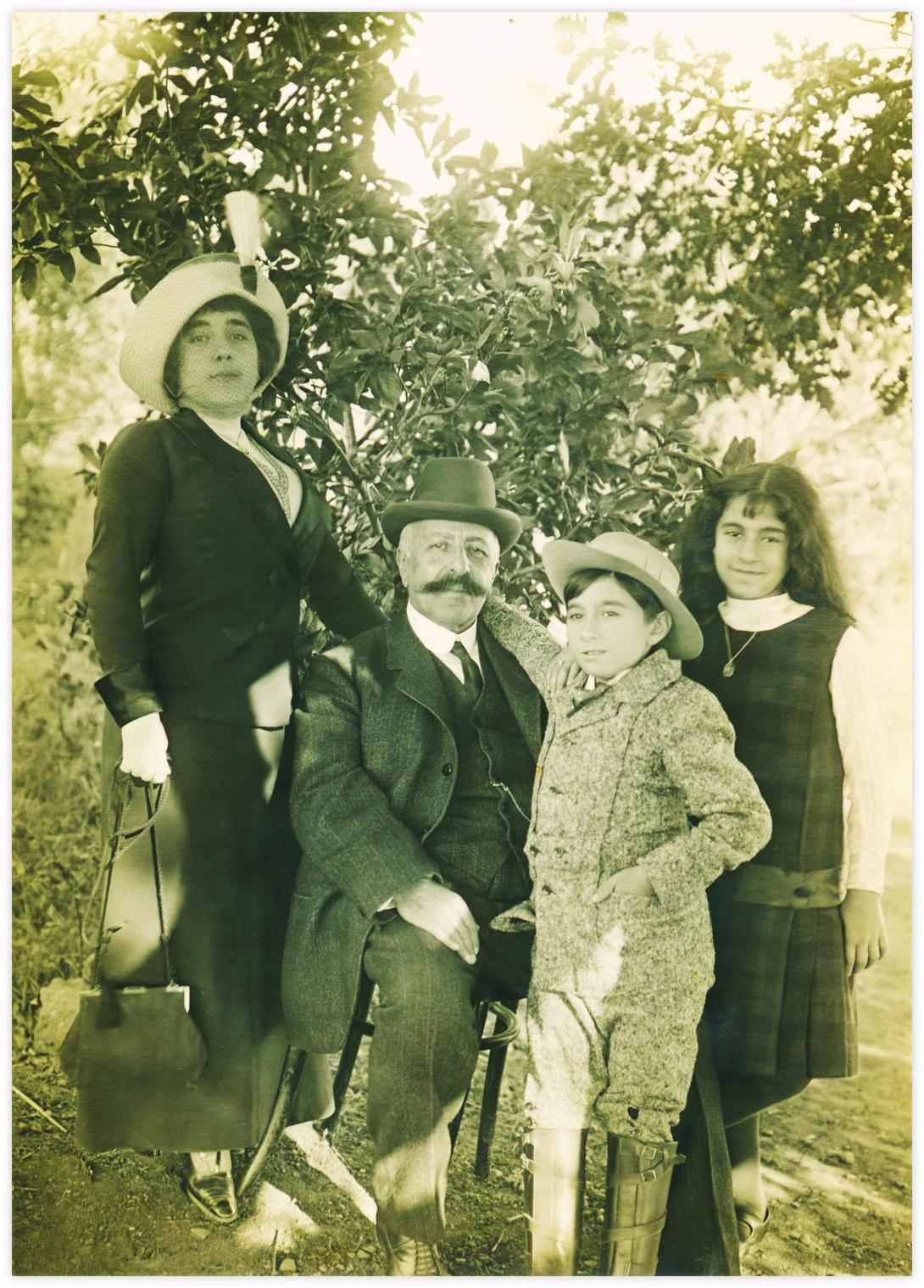 11 Les cousins germains Madeleine (Mady), Stefan et Daria avec Bedros (père de Stefan et Mady) La fratrie Mady et Stefan, avec leur père Bedros sont fiers d'être pris en photo. Daria, leur cousine germaine, sourit de son côté plus timidement. Elle accepte de se joindre à eux trois. Tout le monde est habillé en tenue de ville très soignée. Chapeaux pour tous, sauf pour Daria, la plus jeune, qui a des cheveux longs lâchés en arrière.